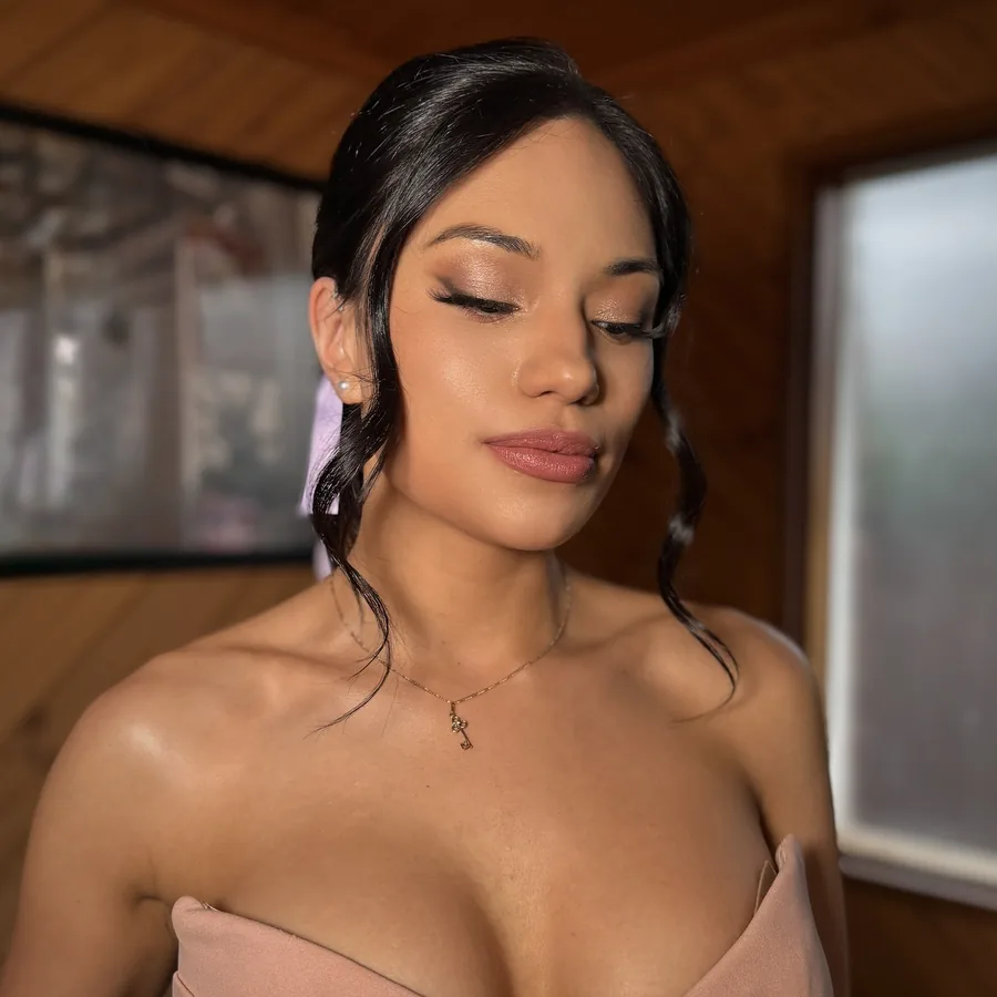 Bridesmaid makeup with a gold shimmer lid and a low updo, worn with a blush gown