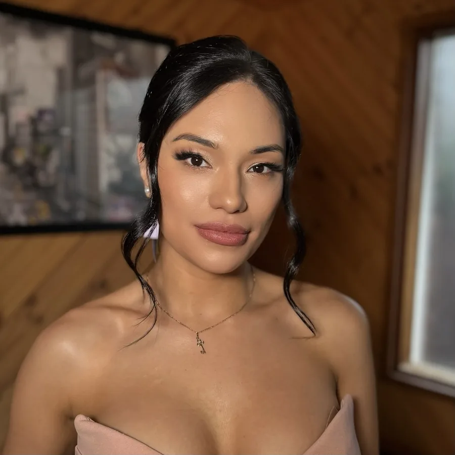Event makeup with lifted lashes and a rosy nude lip, hair pinned back
