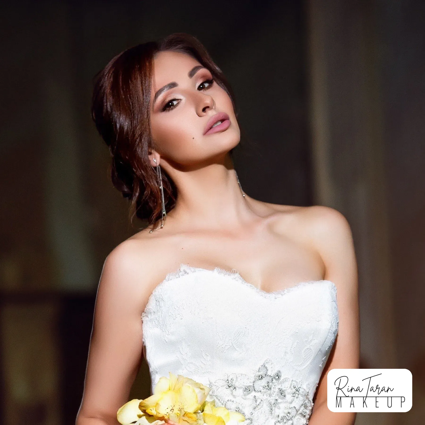 Soft smoky eye and a nude lip on a brunette bride, with a low updo