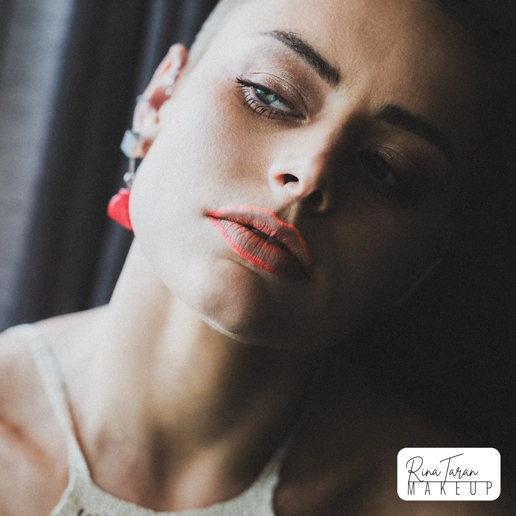 Beauty editorial with a neon coral lip in low window light