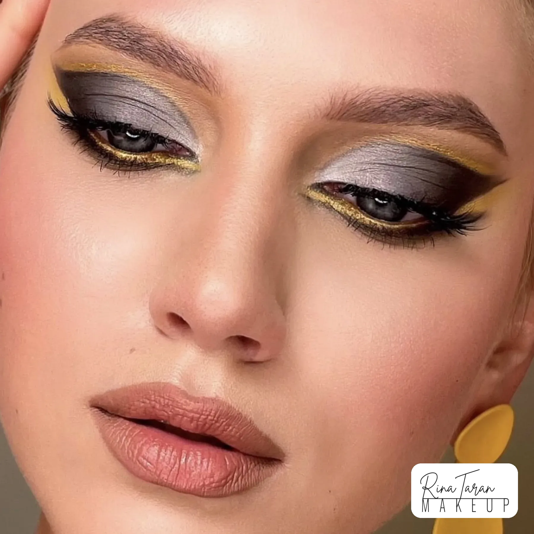 Both eyes closed to show the silver lid with a gold and yellow graphic line