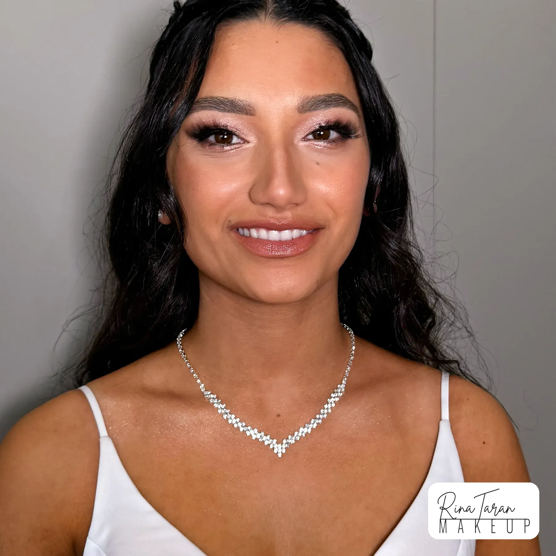 Formal makeup on warm skin kept glowing rather than matte, with a glossy caramel lip