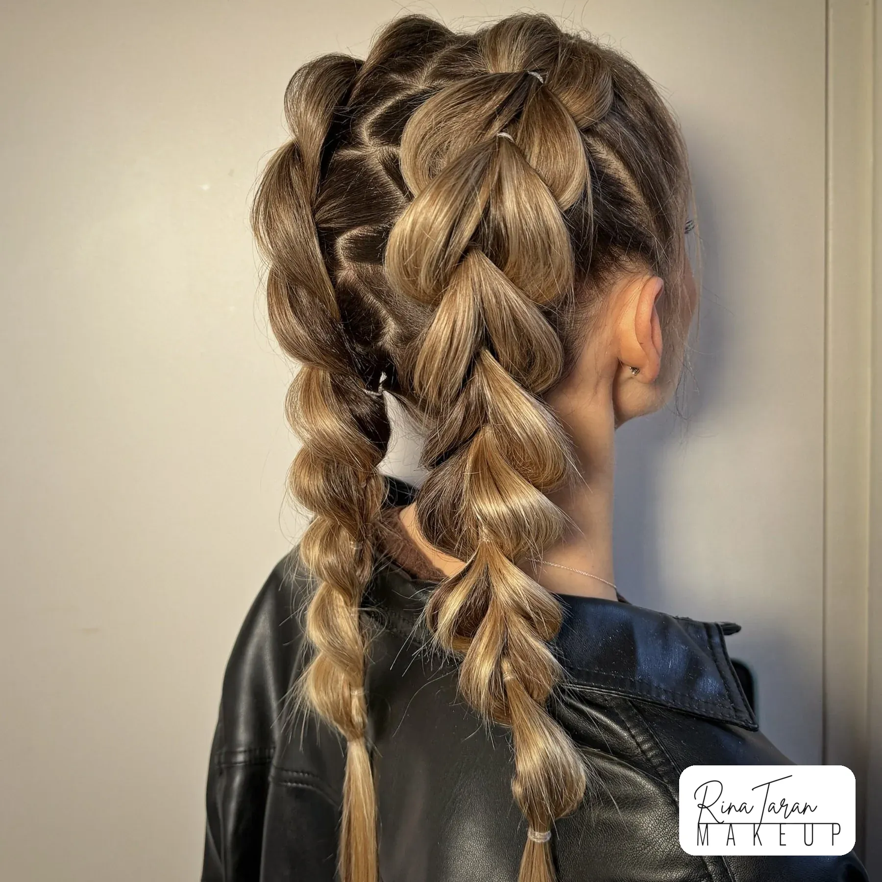Double pull-through braids on long blonde hair, a style that holds all day