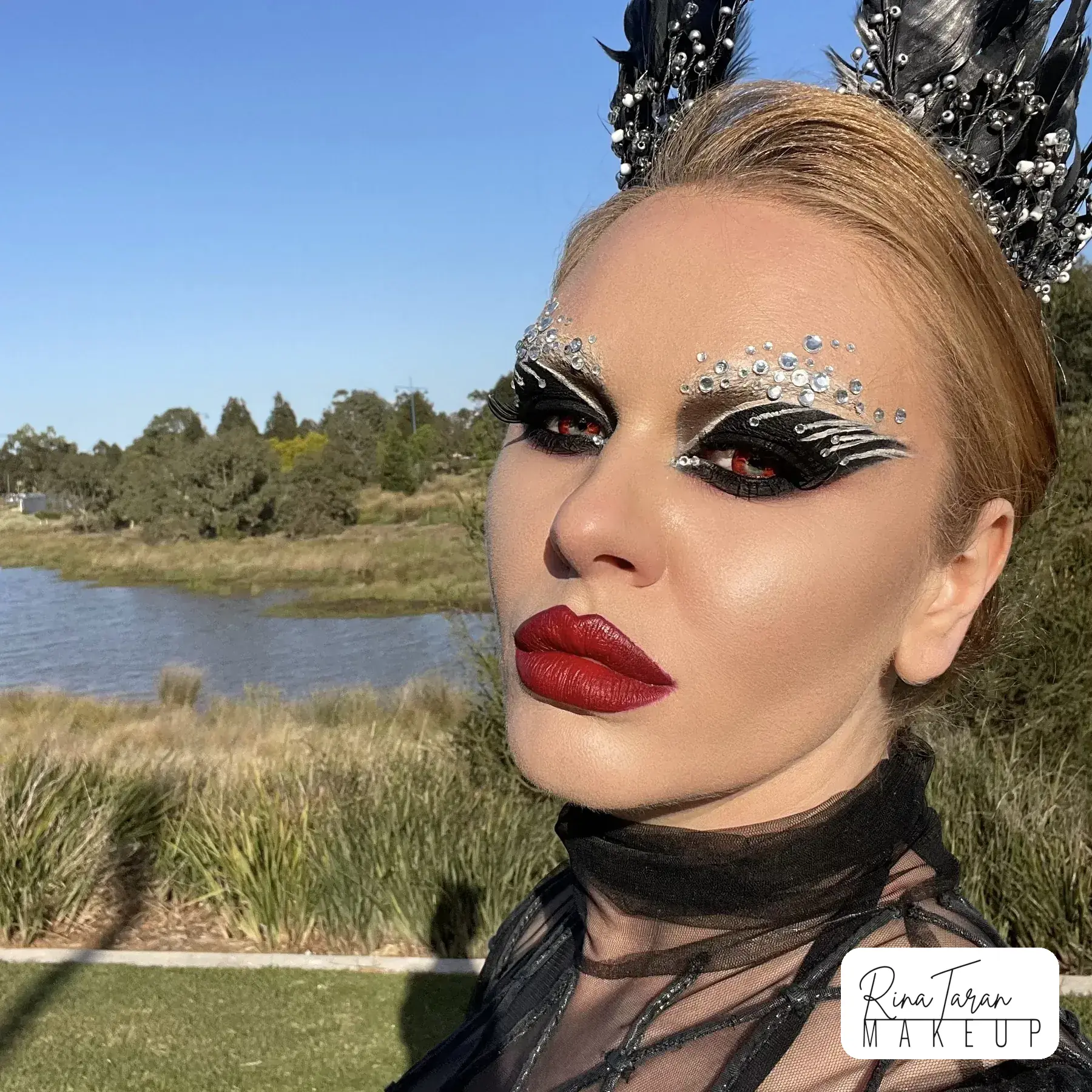 Black swan makeup look with a crystal winged liner and a strong red lip
