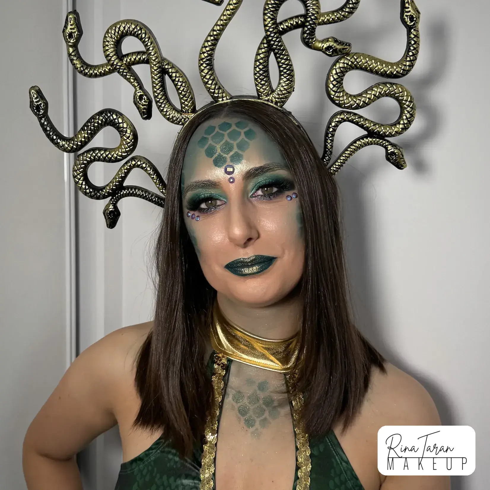 Medusa makeup look with scaled skin, a metallic green lip and gold worked into the brow