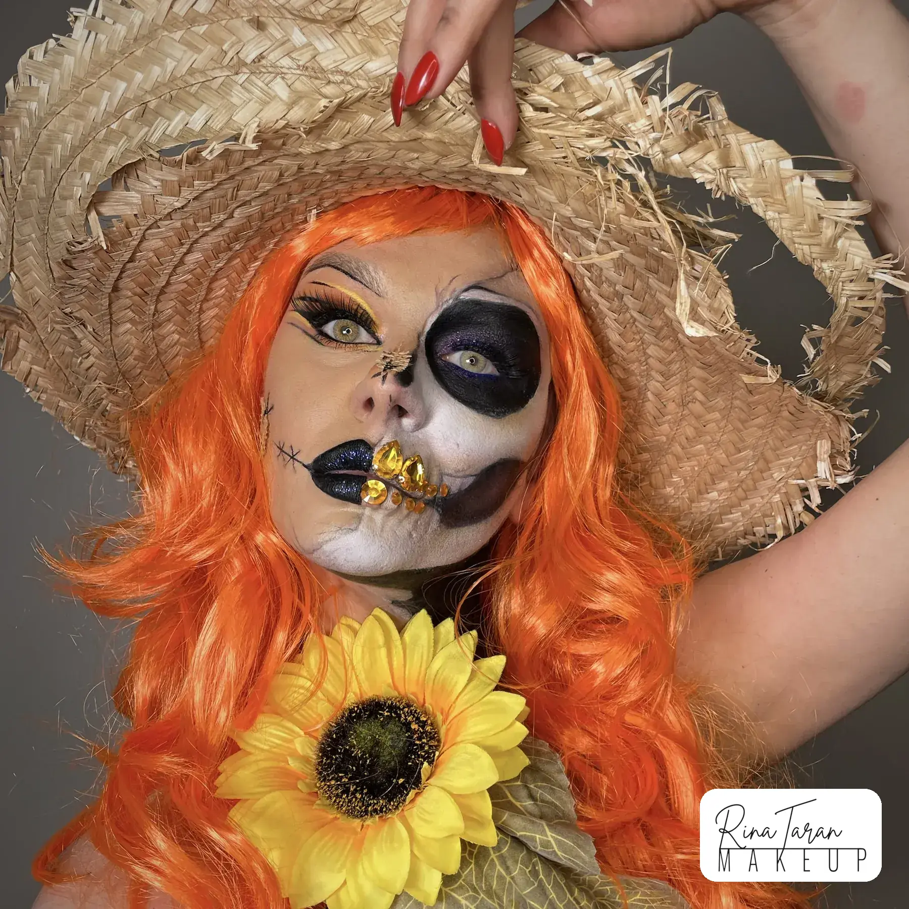 Scarecrow makeup with a stitched mouth, a blacked out eye and sunflowers