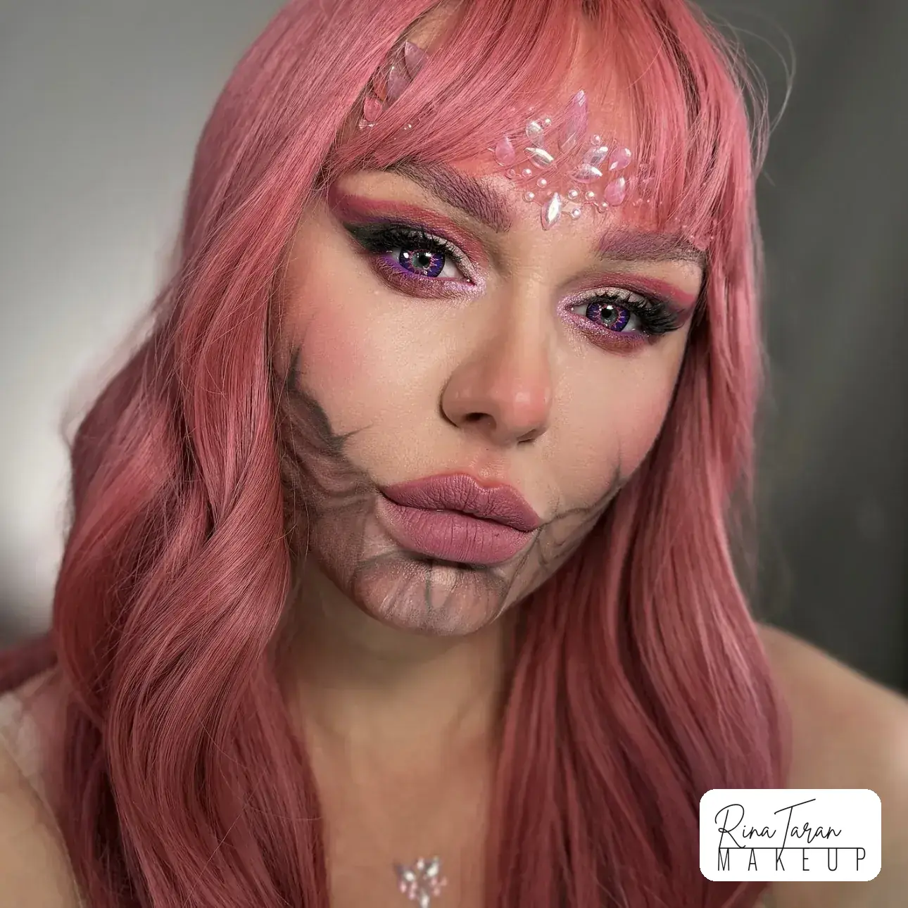 Halloween makeup look with the lower face painted as an exposed jaw, over crystals on the brow