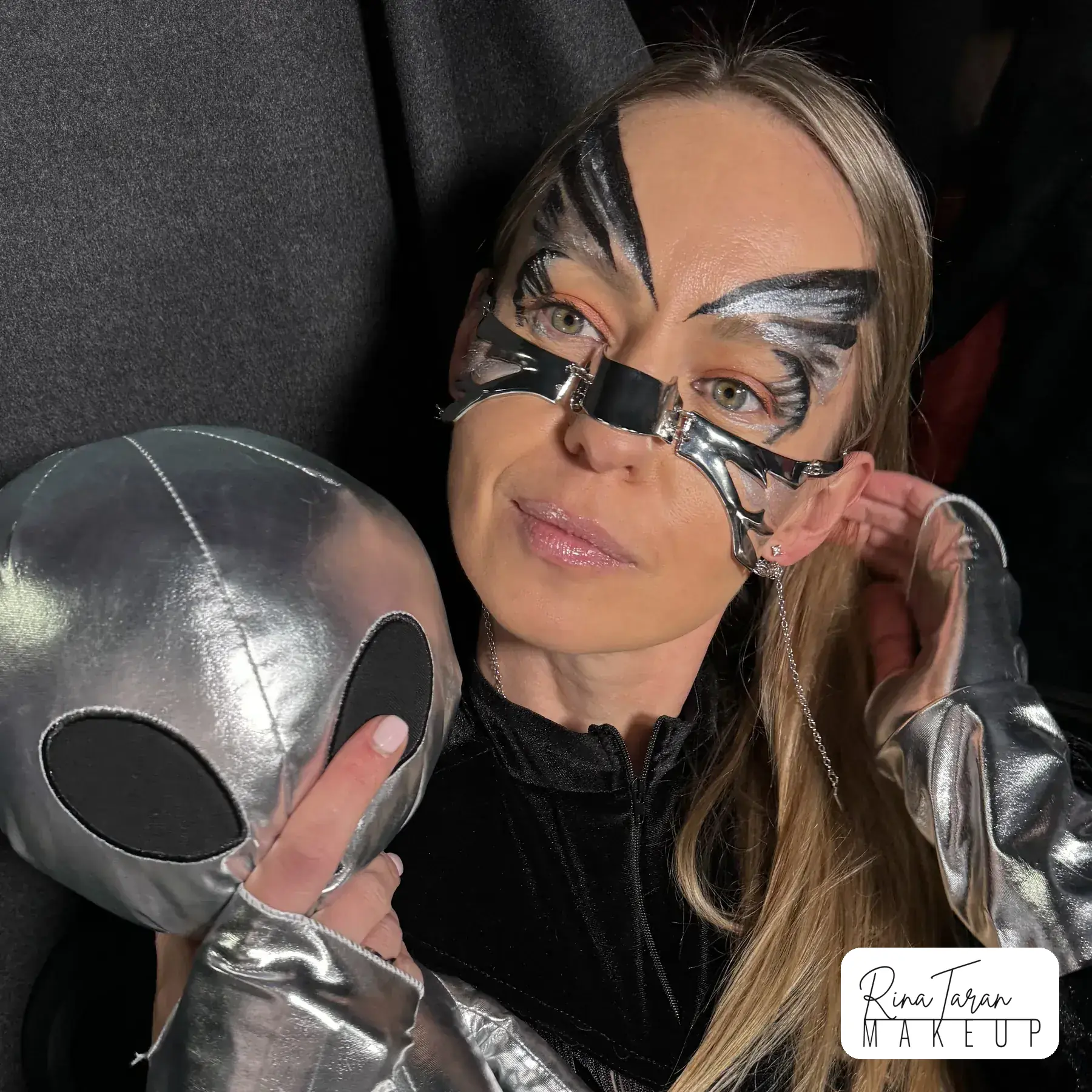 Alien makeup look in silver, with a butterfly shape drawn across both eyes