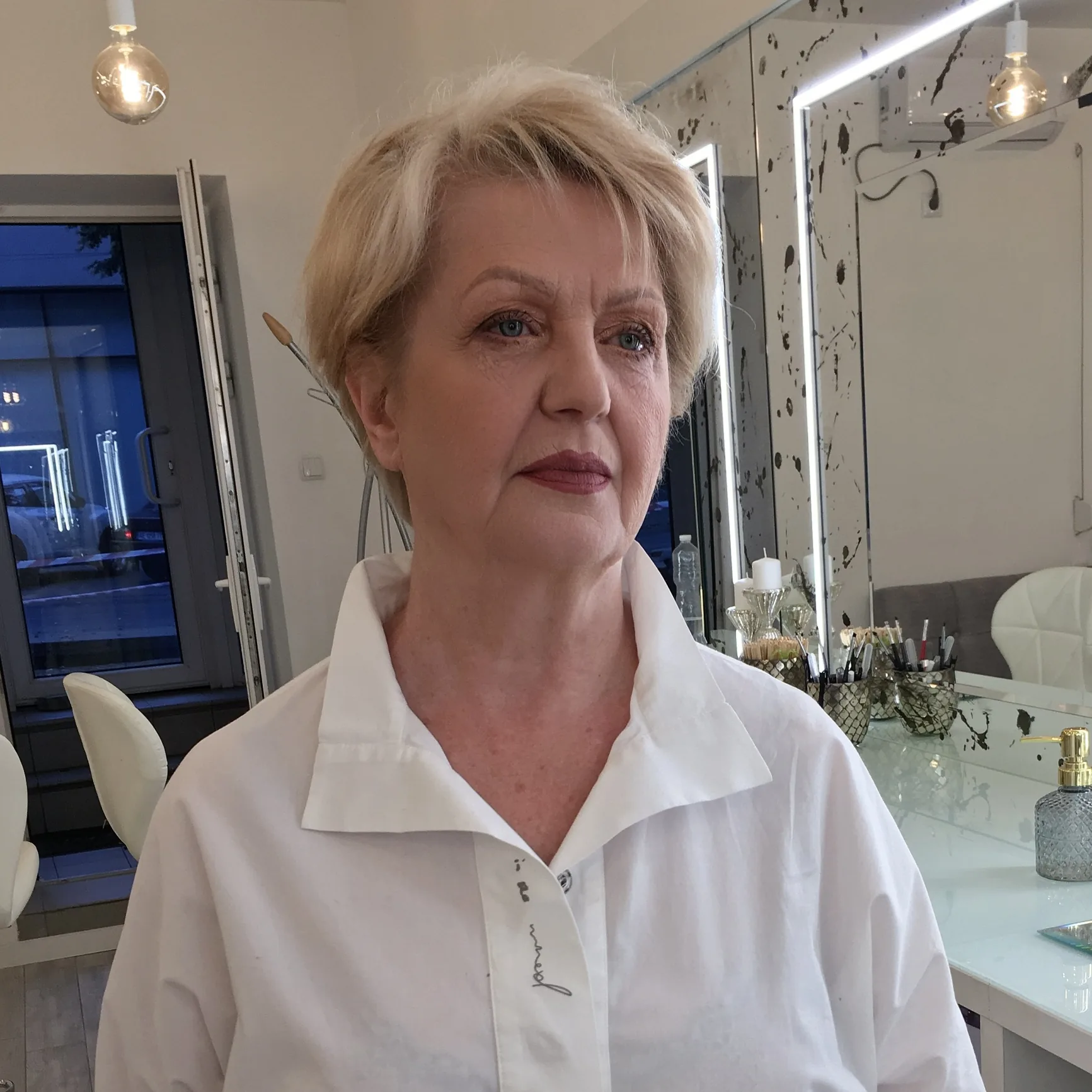 Understated daytime makeup with a muted berry lip on short blonde hair
