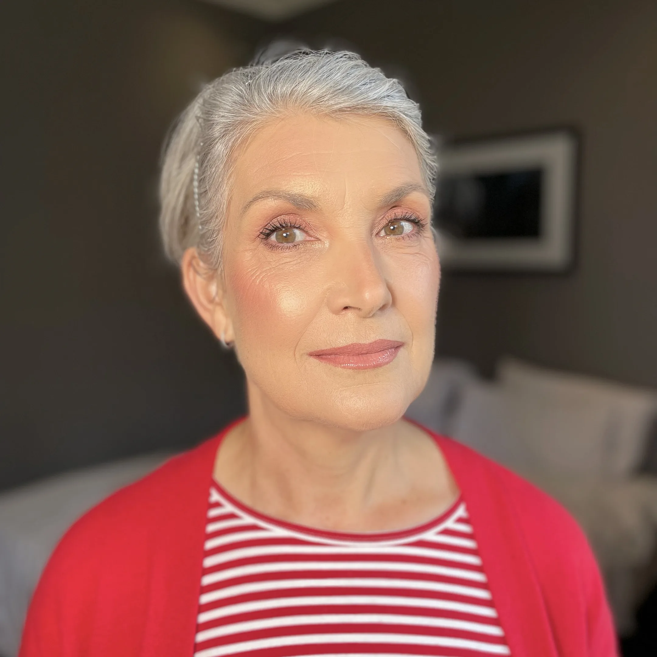 Peach eyeshadow, soft blush and a nude lip on a silver pixie cut