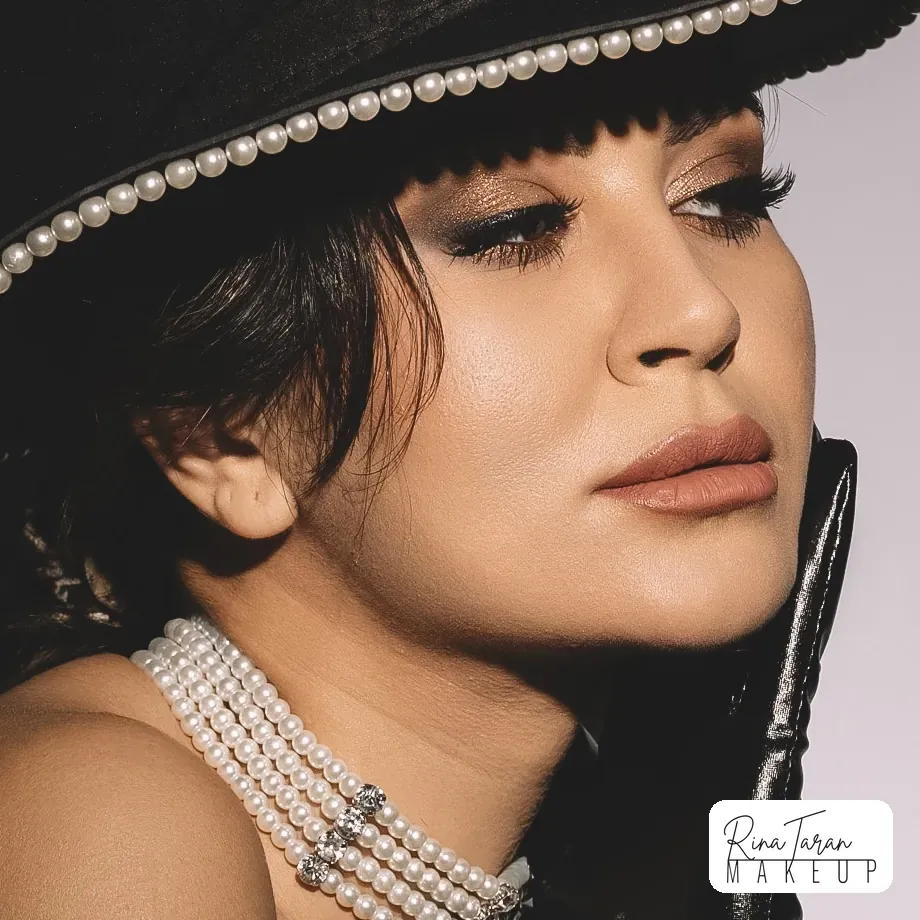 Bronze blended high into the crease with a soft black liner, built to read under a brim