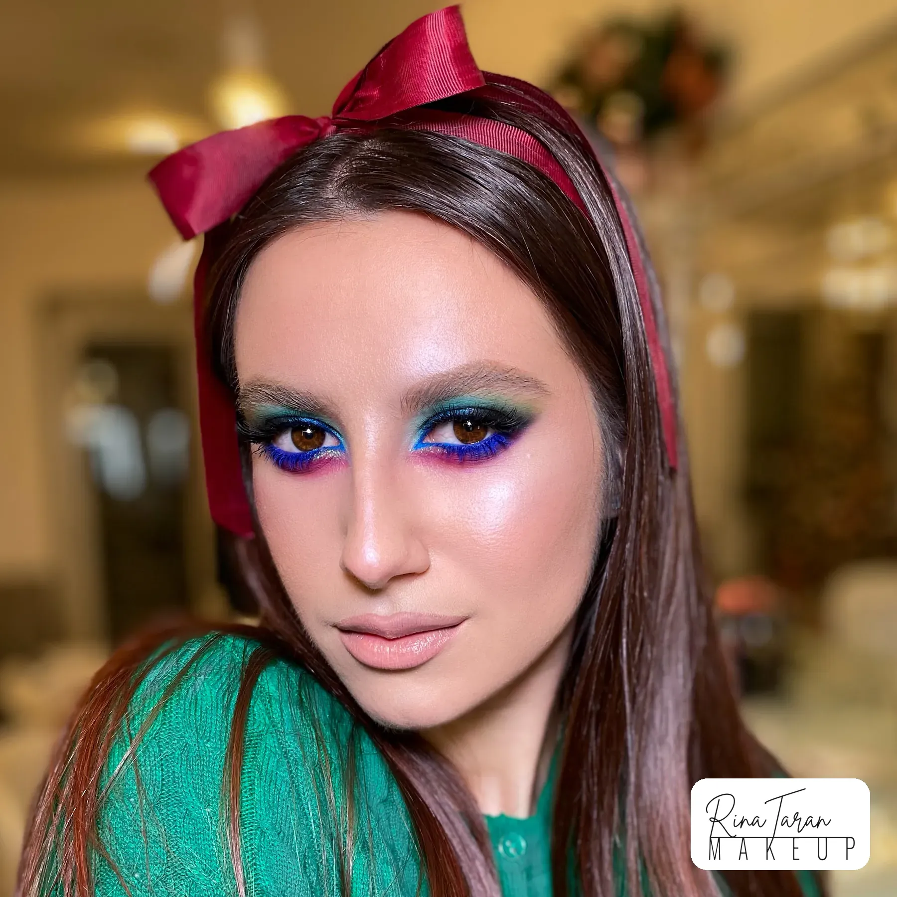 Jewel green and blue shadow melted into a smoky eye, with the skin left glowing