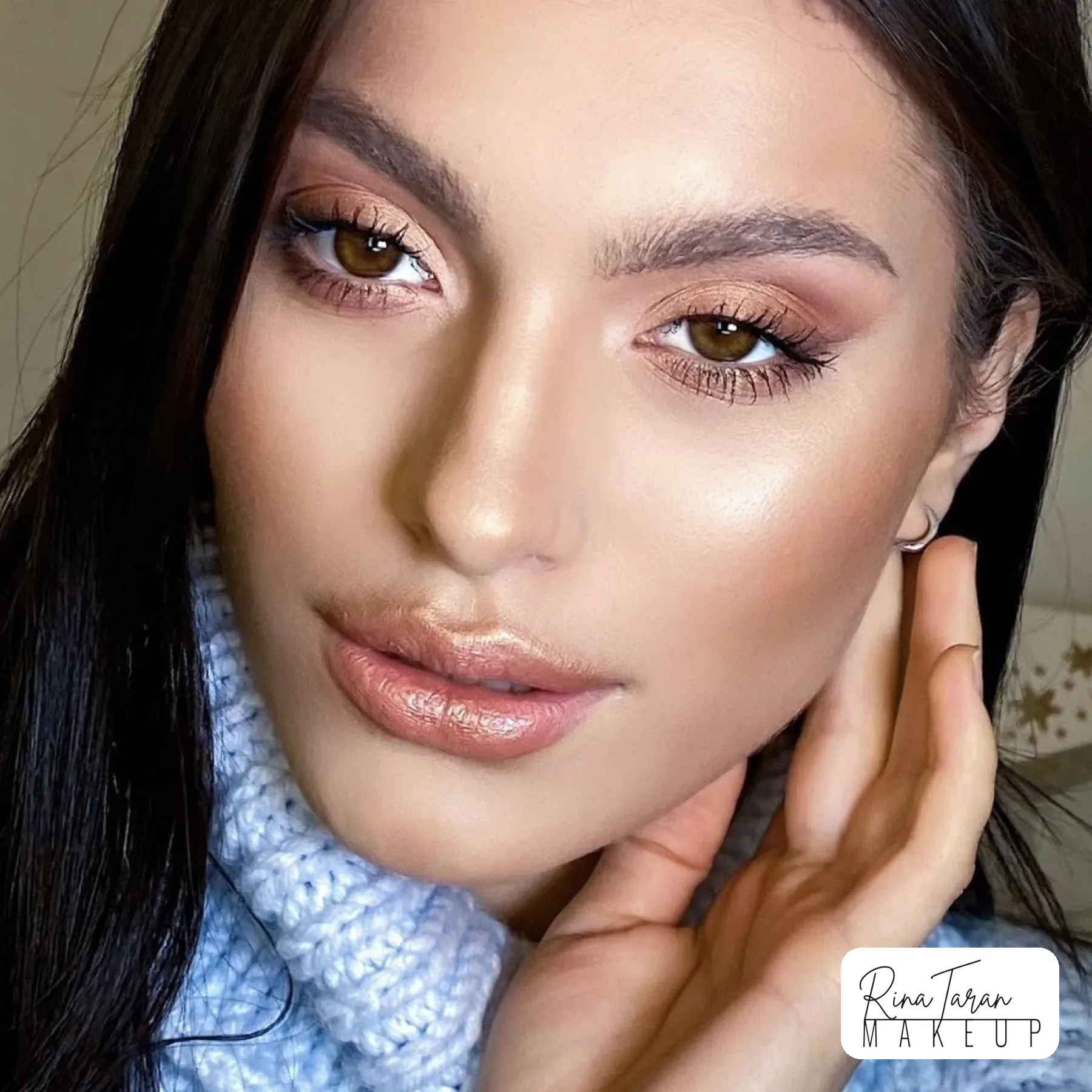 Close-up of glowing skin, peach shadow, soft blush and a glossy lip