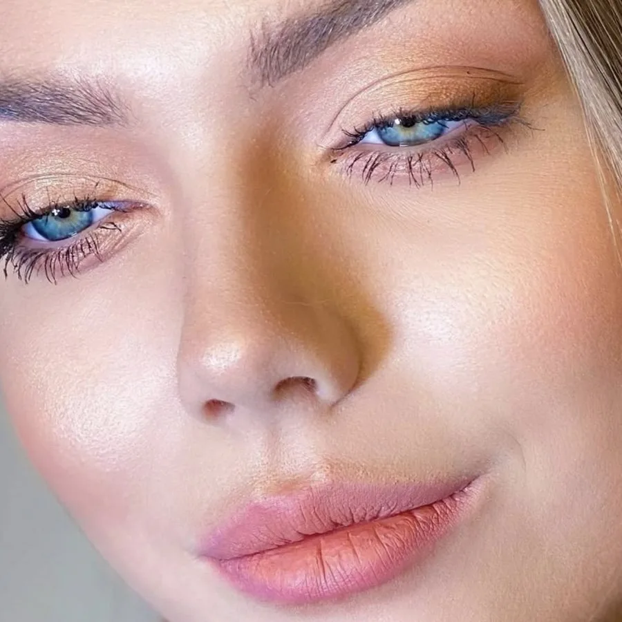 Natural and soft glam makeup close-up with a golden lid and a peach lip