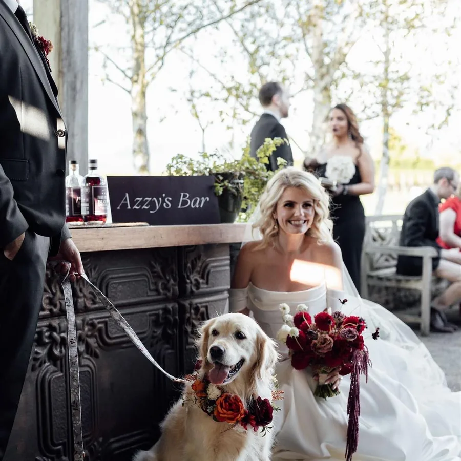 Bride with her bouquet and the dog in a flower collar at a Yarra Valley reception